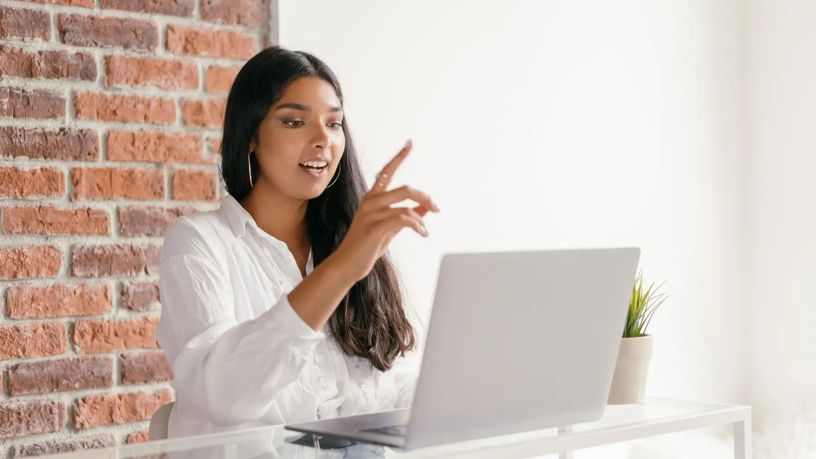 A woman gesturing as she speaks during a video interview on her laptop