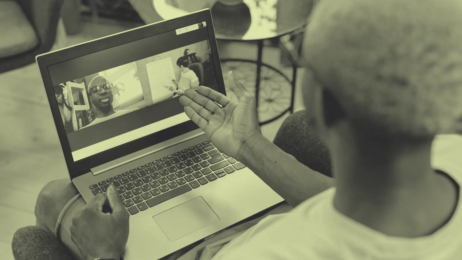 A man on a video call on his laptop at home, the setting most AI job interviews now happen in